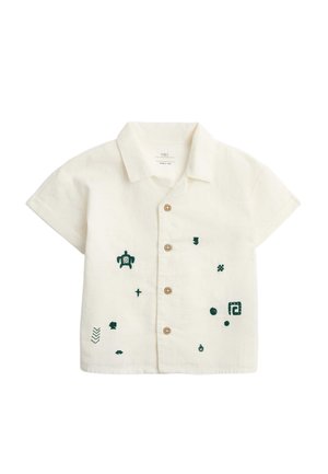 Kortærmet cremefarvet babybluse med krave, træknapper og små mørkegrønne broderede figurer foran.