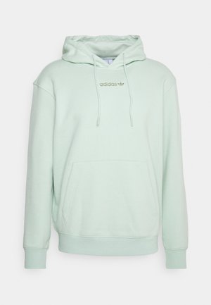 Lichtgroene hooded sweater met voorkantzak en gouden Adidas-logo op de borst, getoond op een effen achtergrond.