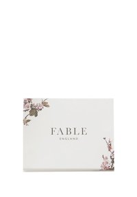Bijela pravokutna papirnata kartica s cvjetnim akcentima u prigušenim bojama, s natpisima "FABLE" i "ENGLAND" ispisanim elegantnim slovima.
