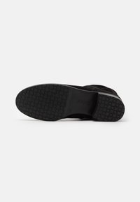 Suela de bota negra con un patrón de tracción hexagonal y la marca "Gabor", tamaño 4 ½, mostrada sobre un fondo blanco liso.