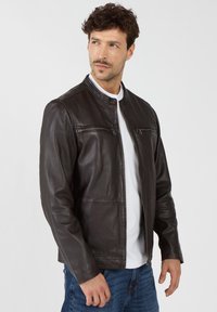 Schwarze Lederjacke mit Stehkragen, zwei Reißverschluss-Brusttaschen und glatter Oberfläche. Merkmale sind ein Frontreißverschluss und eine taillierte Silhouette.