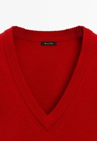 Pull en tricot rouge avec un col en V. Présente des bords côtelés et une texture lisse. L'étiquette indique "Massimo Dutti".