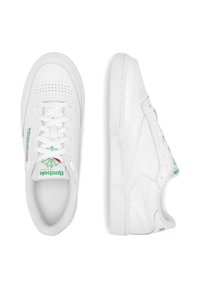 Adidași din piele albă, cu vârf perforat, șireturi plate și accente verzi cu logo pe limbă și lateral. Talpă din cauciuc texturat pentru aderență.