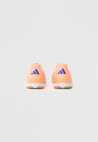 Roosa spordijalatsid tekstuurkaubaga, valgete talladega ja sinise Adidas'i logoga kanna peal. Kerge disain aktiivsete riiete jaoks.