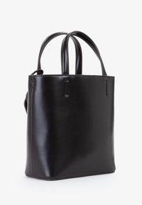 Borsa tote in pelle nera con due manici, texture liscia e forma rettangolare, in posizione verticale su sfondo bianco.