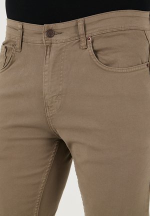 Beige katoenen blend jeans met een slim fit, voorzien van voorzakken, een soepele textuur en een klassieke metalen knoopsluiting.