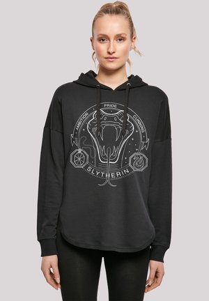 Svart hettegenser med en løs passform, med et grått Slytherin-emblem med et slangedesign og tekst. Myk stoff med en glatt tekstur.