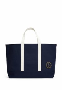 Borsa tote in tela blu navy con manici bianchi, caratterizzata da un dettaglio in rilievo del logo tondo ricamato. Forma rettangolare strutturata con una sottile texture.