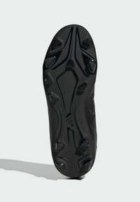 Suela de zapato deportivo negra con diseño texturizado, que presenta tachuelas triangulares y circulares para tracción, y un patrón distintivo a lo largo de los bordes.