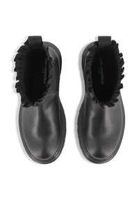 Bottines noires avec une tige en cuir lisse, un détail froncé élastique au niveau du col et une semelle en caoutchouc texturé.