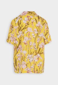 Kurze Ärmeln Bluse aus gelbem Stoff mit floralem Muster in rosa und braunen Akzenten. Lockere Passform und Hemdkragen-Design.