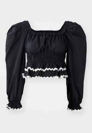 Blusa nera corta con maniche a palloncino, vita arricciata e bordo bianco a scallop lungo l'orlo e le maniche. Realizzata in tessuto leggero.