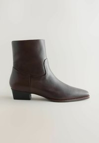 Dark brown leather ankle boot with low black heel, pointed toe, and smooth finish, shown from the side on a neutral background.
