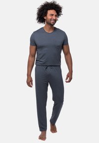 Grijze katoenen pyjama-set bestaande uit een t-shirt met korte mouwen en een pocket, en broek met trekkoord, met een losse pasvorm en lichtgewicht stof.