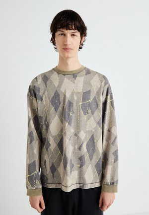 Long-sleeve shirt in gray with an argyle pattern, featuring yellow accents. The fabric has a textured appearance, with a round, contrasting neckline.