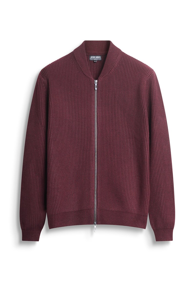 Bordo zip-up dukserica s rebrastom teksturom, s pojasom oko vrata i manžetama. Ima središnji patentni zatvarač i uski kroj.