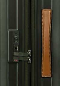 Maleta negra texturizada con un candado de combinación, tiradores de doble cremallera y un asa lateral de cuero marrón.