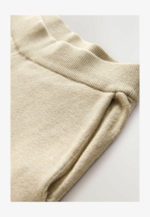 Beige fleece jogger pants with a ribbed waistband, featuring a soft texture and folded hems for a relaxed fit. Ideal for casual wear.