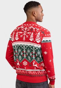 Maglione natalizio rosso lavorato a maglia con motivi bianchi e verdi delle festività, tra cui alberi, fiocchi di neve e renne; polsini e orlo a coste.