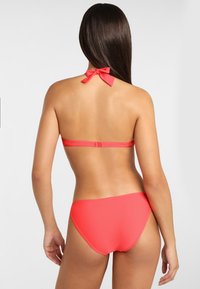 Korallenfarbene Bikini-Set mit einem Neckholder und einer Schleifendetail sowie nahtlosem Unterteil. Glatte Textur mit passgenauer Form für Komfort.