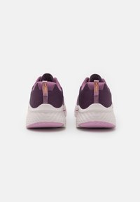 Chaussures de sport violettes et roses avec une tige en tissu texturé, une semelle intermédiaire blanche rembourrée et une semelle extérieure rose à motifs. Accents en caoutchouc au talon.