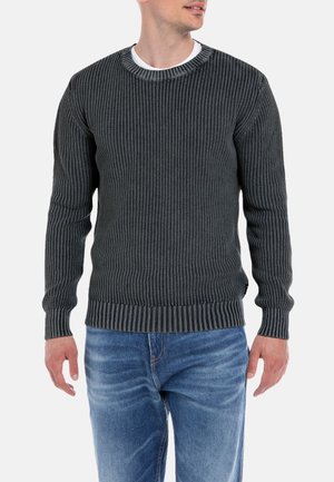 Dunkelgrauer gestrickter Pullover mit einer gerippten Textur, rundem Halsausschnitt und kontrastierendem gestreiftem Kragen. Kombiniert mit blauen Jeans.