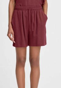 Shorts bordeaux avec un taille élastique, cordon de serrage et poches latérales. Fabriqués à partir d'un tissu doux et léger avec une coupe décontractée.