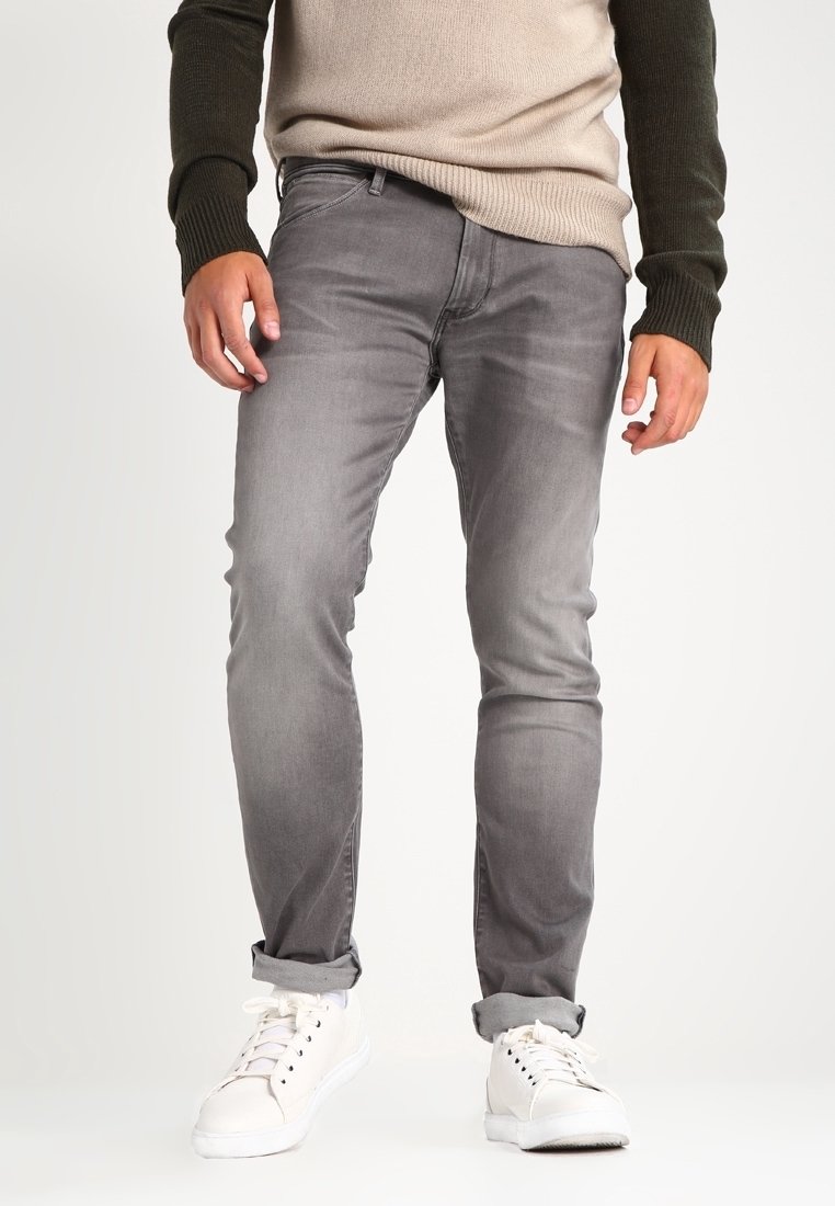 Grå denimjeans med slim fit, med subtila blekningar, fem fickor och uppvikta muddar. Matchas med vita sneakers.