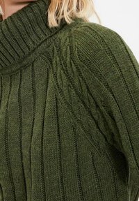 Dunkelgrüner, gerippter Strickpullover mit hohem Rollkragen und Kabelstrickdetails an den Schultern, mit einer weichen Textur.