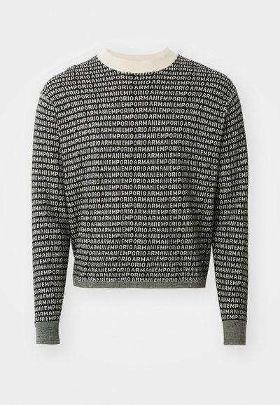 Pulover scurt alb-negru cu un model repetat de logo, cu guler și manșete ribbed și o textură moale de tricot.