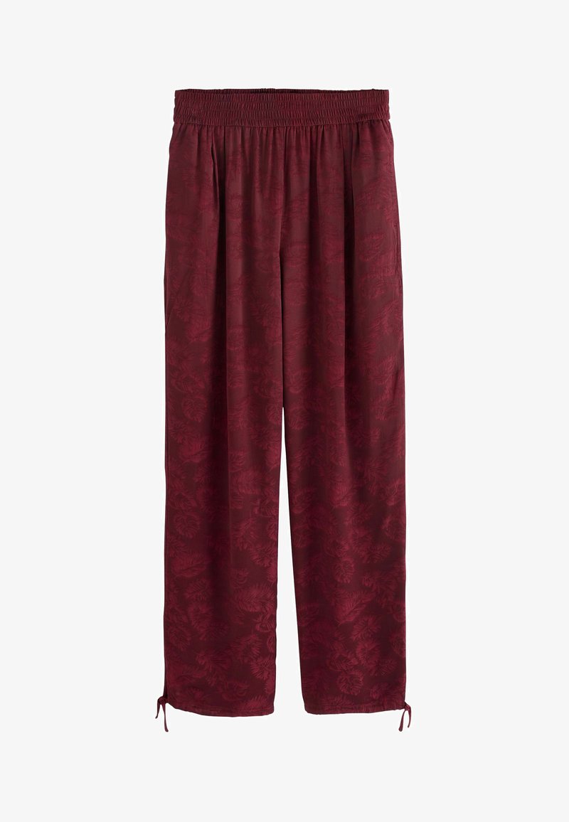 Burgundijas krāsas brīvi pieguļošas bikses ar elastīgu jostu, ar subtīlu ziedu rakstu un regulējamiem saitēm apakšmalā. Gluda tekstūra.