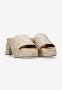 Infradito espadrille intrecciate beige con una fascia larga e un tacco spesso e testurizzato caratterizzato da un design a strati.