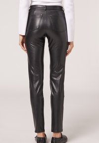Černé kožené kalhoty se slim fit střihem, s dvěma zadními kapsami a hladkou, lesklou texturou, navržené s minimálními švy.