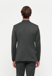 Grijze suitjack met herringbone-patroon en een slim fit. Enkele rugventilatie, geknipte revers en drieknoop-detailing bij de manchetten.