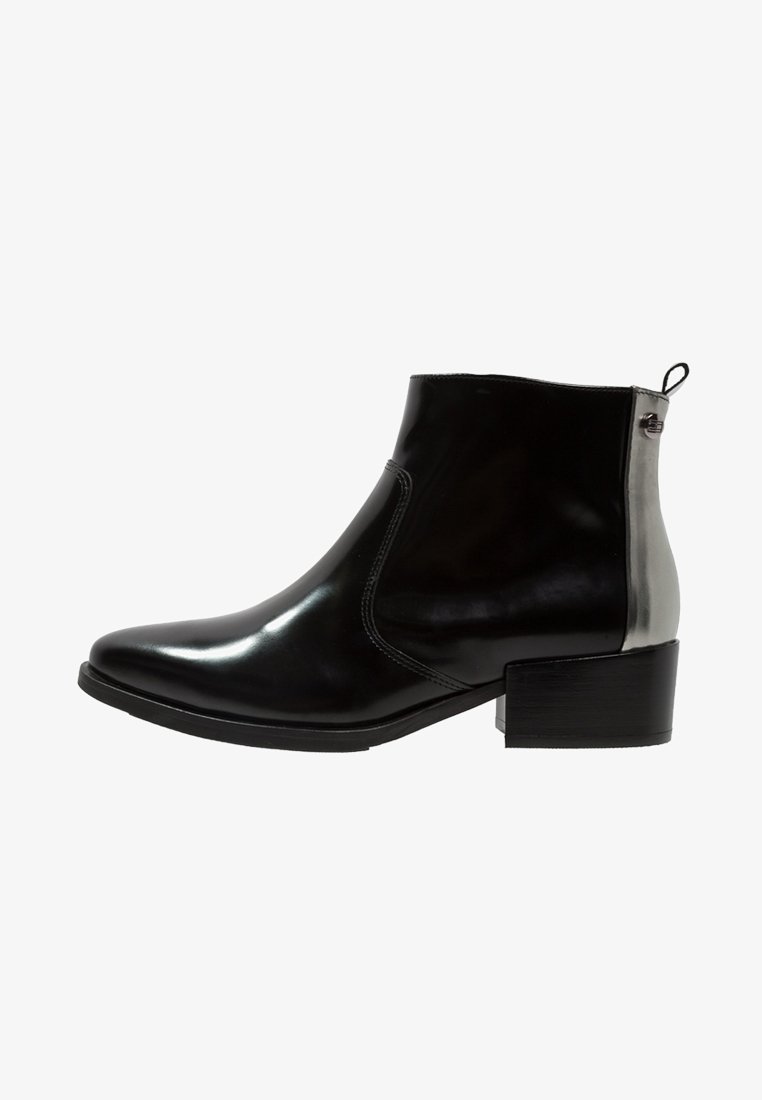 Bottine en cuir noir avec petit talon bloc, bout pointu, panneau argenté et languette à l'arrière.