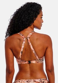 Sporty bra with a multicolored reptile pattern, featuring a racerback design, adjustable straps, and a clip closure at the back.