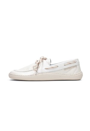 Chaussure bateau en cuir blanc avec des lacets beiges, une couture mocassin et une semelle en caoutchouc beige, vue de côté sur un fond blanc.