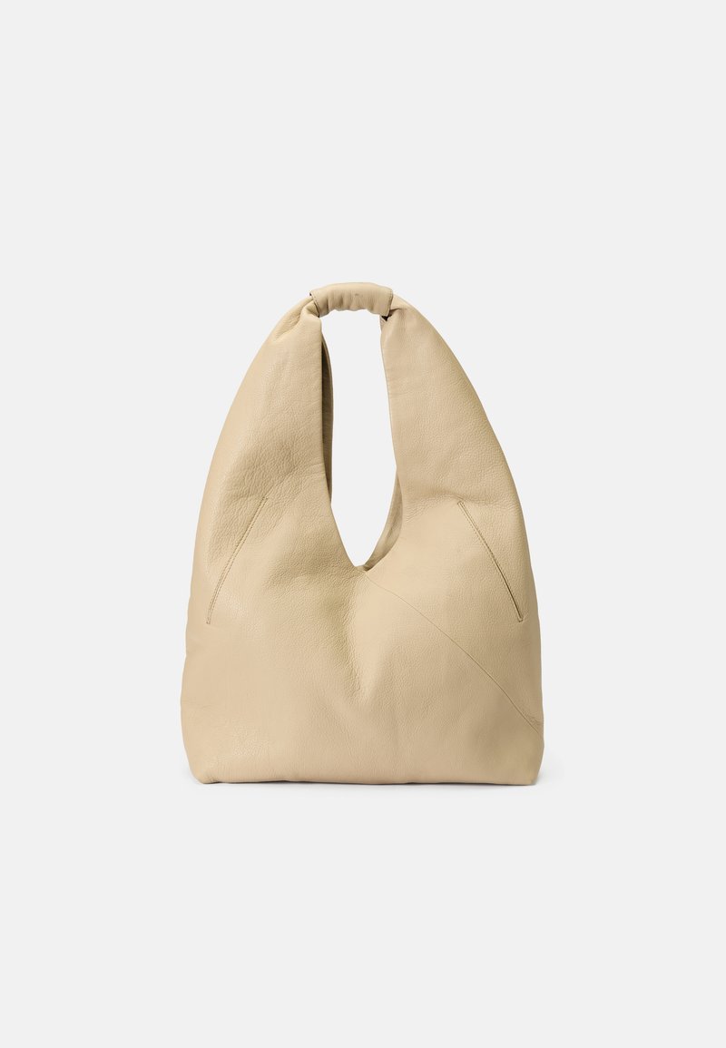 Beige leather shoulder bag with a unique cutout design, soft texture, and a knotted handle; features angled seams for added detail.