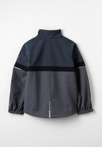 Mørkegrå jakke med høj krave, elastiske manchetter og markante sorte stribedetaljer over skuldrene. Stoffet har en glat tekstur.