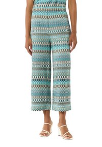 Pantalons larges imprimés dans des nuances de turquoise, crème et marron avec un motif zigzag. Tissu doux et léger avec une coupe décontractée.