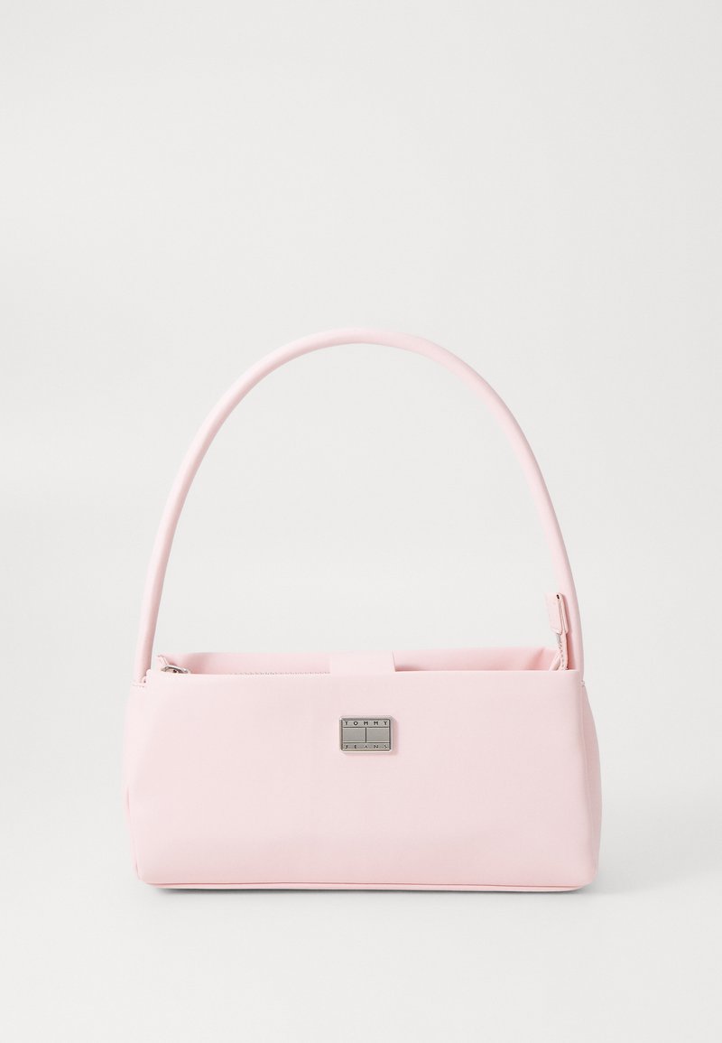 Pink rektangulær håndtaske lavet af glat syntetisk materiale. Har et buet håndtag og et metallisk logo som accent foran. Lynlås lukning.