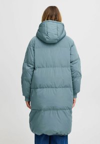 Duga, svijetloplava puffer jakna s kapuljačkom, s kvadratnim uzorkom, rebrastim manžetama i ravnim krojem. Glatka, sjajna tkanina.