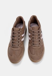Baskets en cuir marron avec des accents en suède beige, présentant des rayures roses, un bout rond, des détails perforés et des lacets plats ton sur ton.