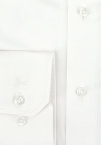 Witte dressshirtmanchet en -mouw met parelachtige knopen en fijne stikseldetails op gladde stof.