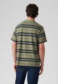 Grøn t-shirt med korte ærmer, der har horisontale navy-blå striber, rund halsudskæring og en afslappet pasform. Fremstillet af blødt bomuldsstof med en struktureret overflade.