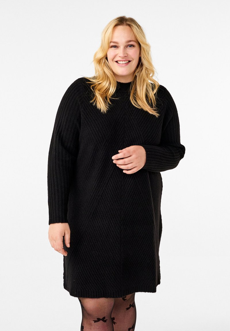 Svart tröjdress med ribbad textur, som har rund halsringning, långa ärmar och detaljer med diamantmönster.