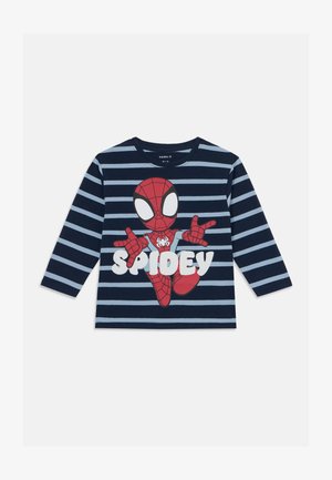 Pikkade varrukatega tumesinine ja helesinine triibuline T-särk, millel on suur Spider-Mani graafika ja tekst "SPIDEY" rasvastes valgetes tähtedes.