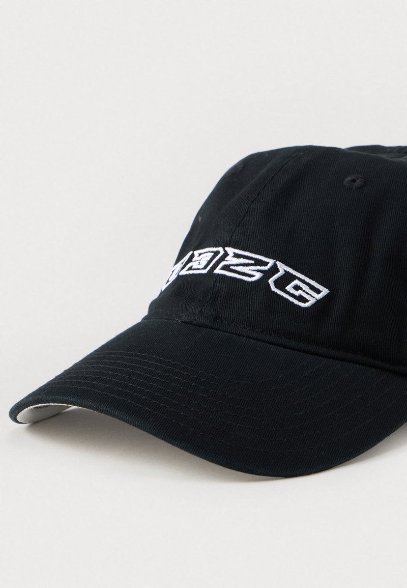 Cappellino da baseball in cotone nero con visiera curva, caratterizzato da testo ricamato bianco sul davanti e una superficie testurizzata.