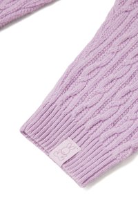 Svetr s pleteným vzorem v světlé levandulové barvě, s ribbovanými okraji a malou cedulkou s designem králíčka přišitým na lemu.
