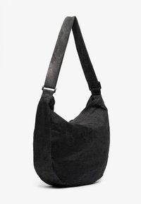 Black, slouchy shoulder bag with a wide strap, featuring a soft, textured fabric and a minimalist design.